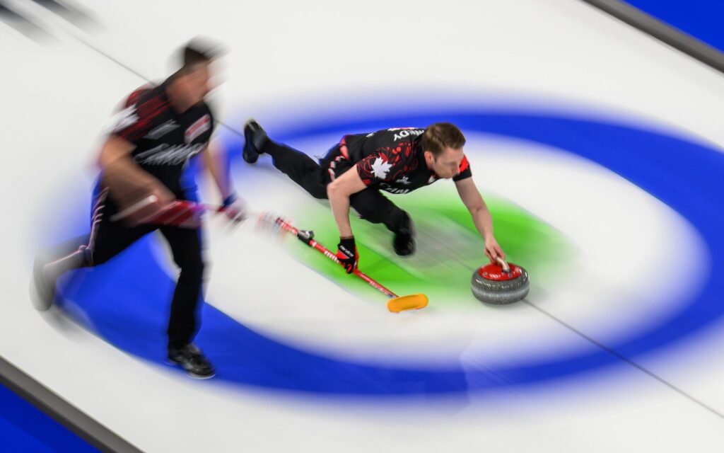 curling-players-sweeping-a-red-stone-on-ice-motion-blur-emphasizes-speed-and-action – Robótica, Inteligencia Artificial, Automatización