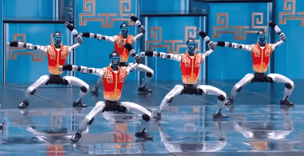 five-humanoid-robots-in-red-vests-perform-synchronized-movements-on-a-shiny-stage – Robótica, Inteligencia Artificial, Automatización