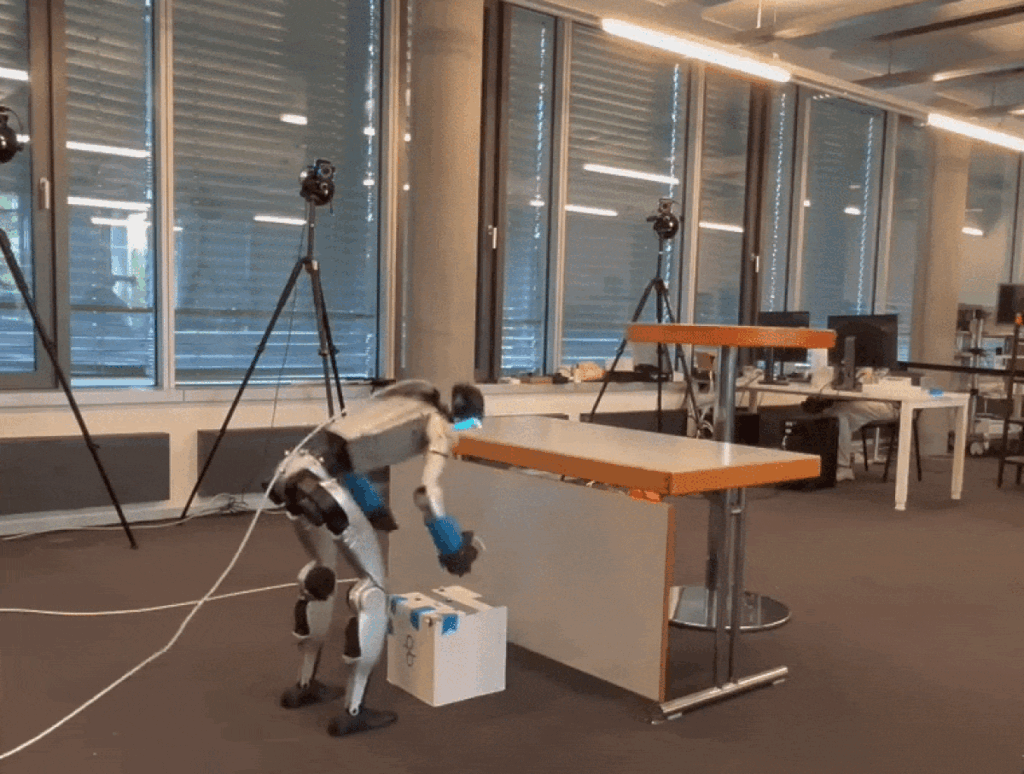 humanoid-robot-picks-up-a-box-and-climbs-onto-a-table-in-a-modern-lab-workspace – Robótica, Inteligencia Artificial, Automatización